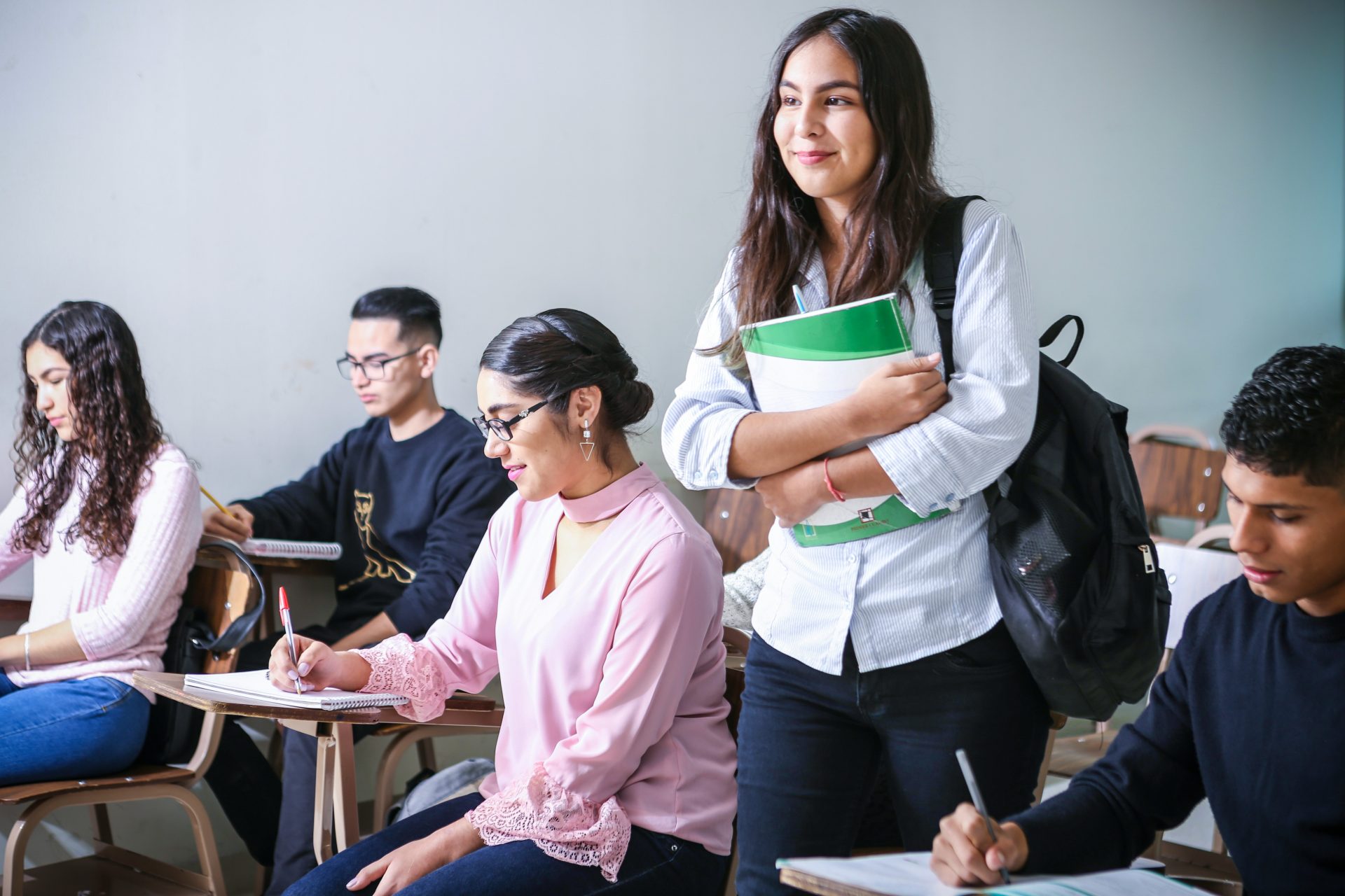 femme portant un manuel scolaire blanc et vert